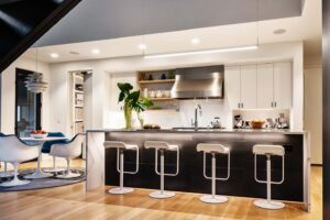 A kitchen with stools and a table in the background