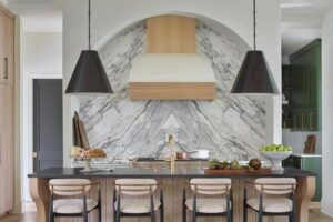 A kitchen with a large island and a marble wall.