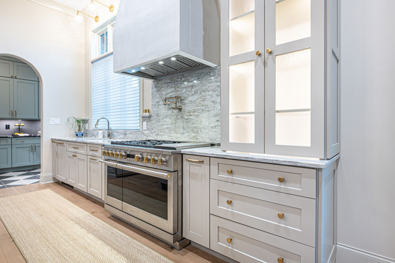A kitchen with white cabinets , stainless steel appliances , and a stove.