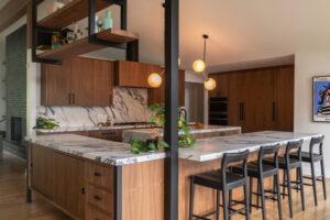 A kitchen with marble counter tops , wooden cabinets , and a large island.