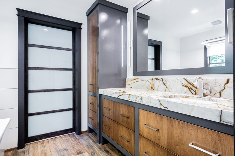 A bathroom with two sinks , a mirror and a marble counter top.
