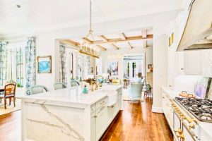 A kitchen with a large island and a stove top oven.