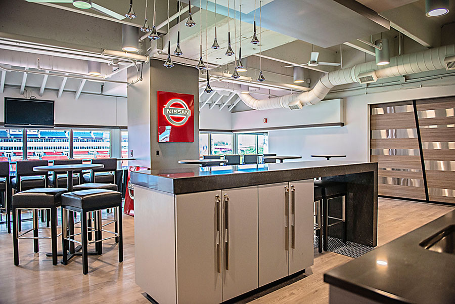 A large room with tables and chairs and a nissan sign on the wall.