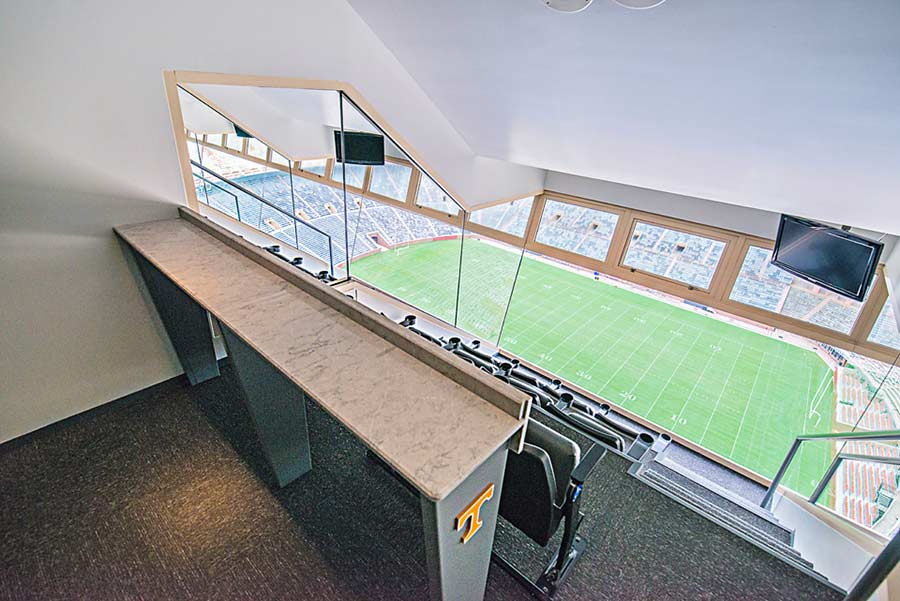 A room with a large window overlooking a soccer field.