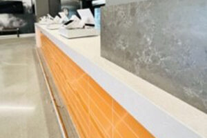 A long wooden counter with a white counter top in a room.