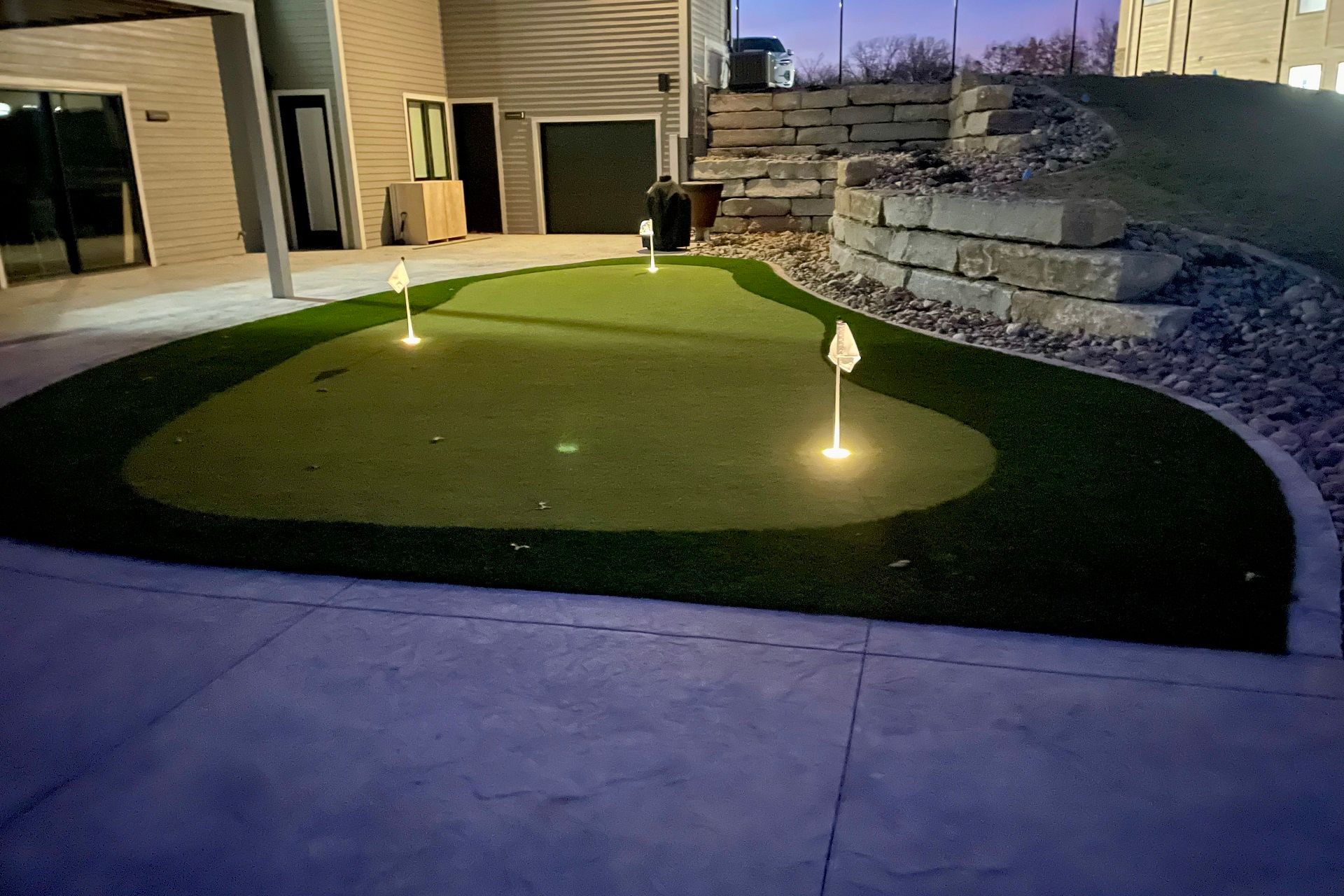 a golf course is lit up at night in front of a house