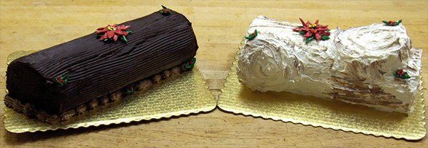 A chocolate cake and a white cake are sitting on a table.