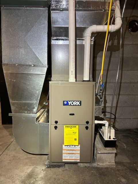 A york air conditioner is sitting in a basement.