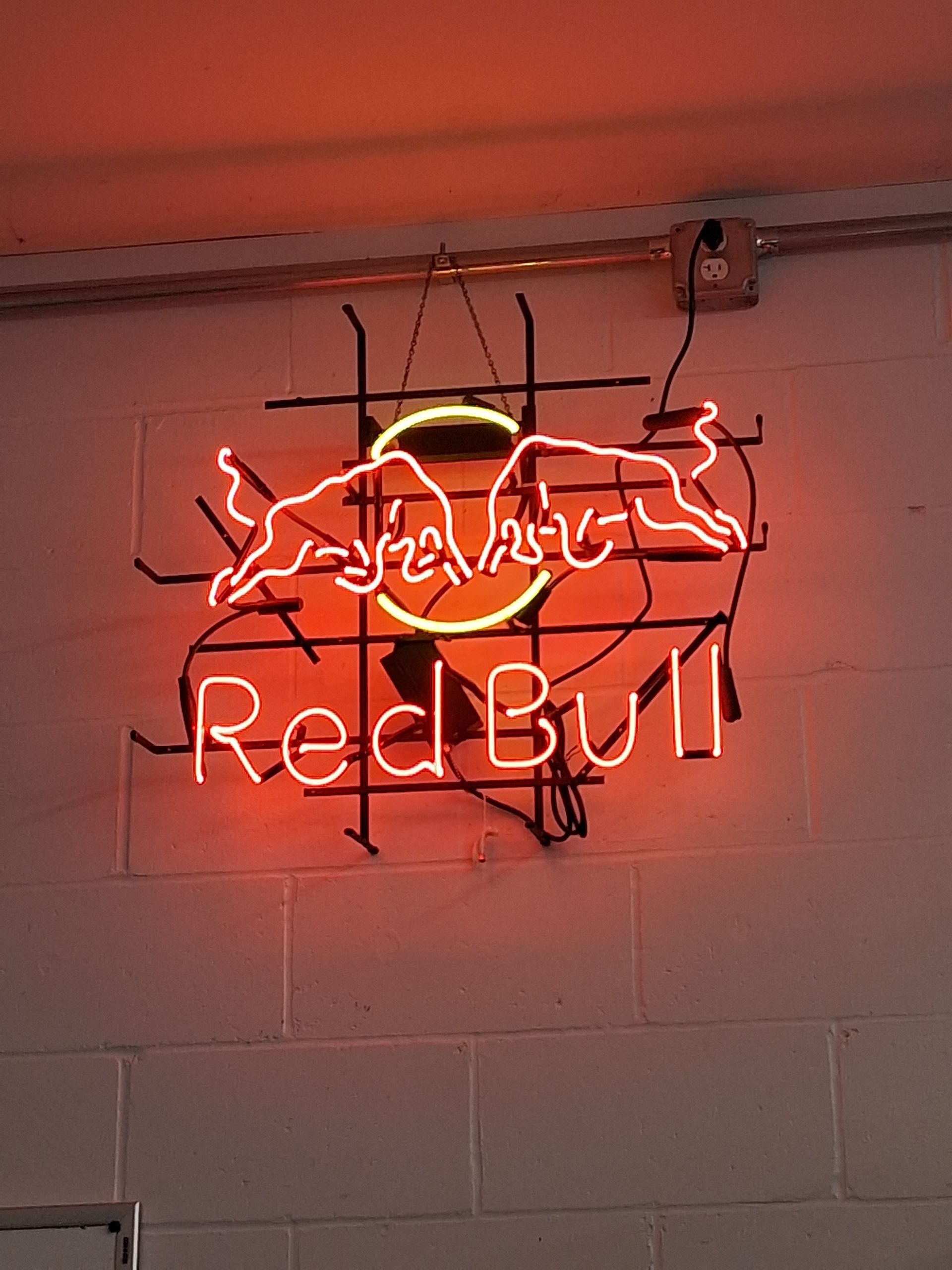 Red Bull neon sign glowing red on a wall