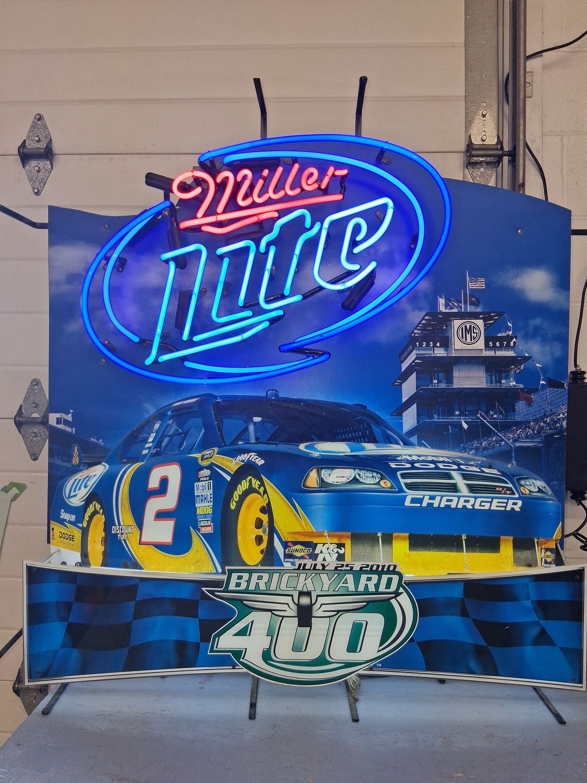 Blue NASCAR race car display with neon Miller Lite sign and 