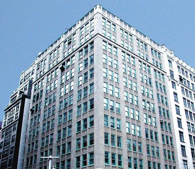 Tall white office building with many windows against a blue sky