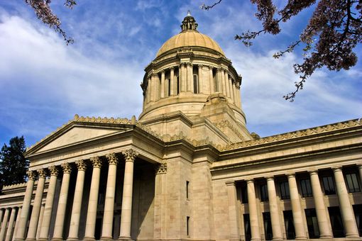 Classical government building with a domed rotunda and tall columns under a blue sky