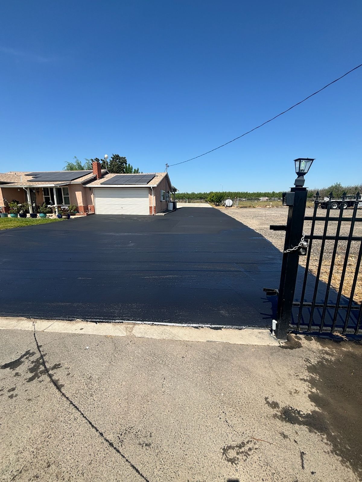 A house with a driveway and a fence in front of it.