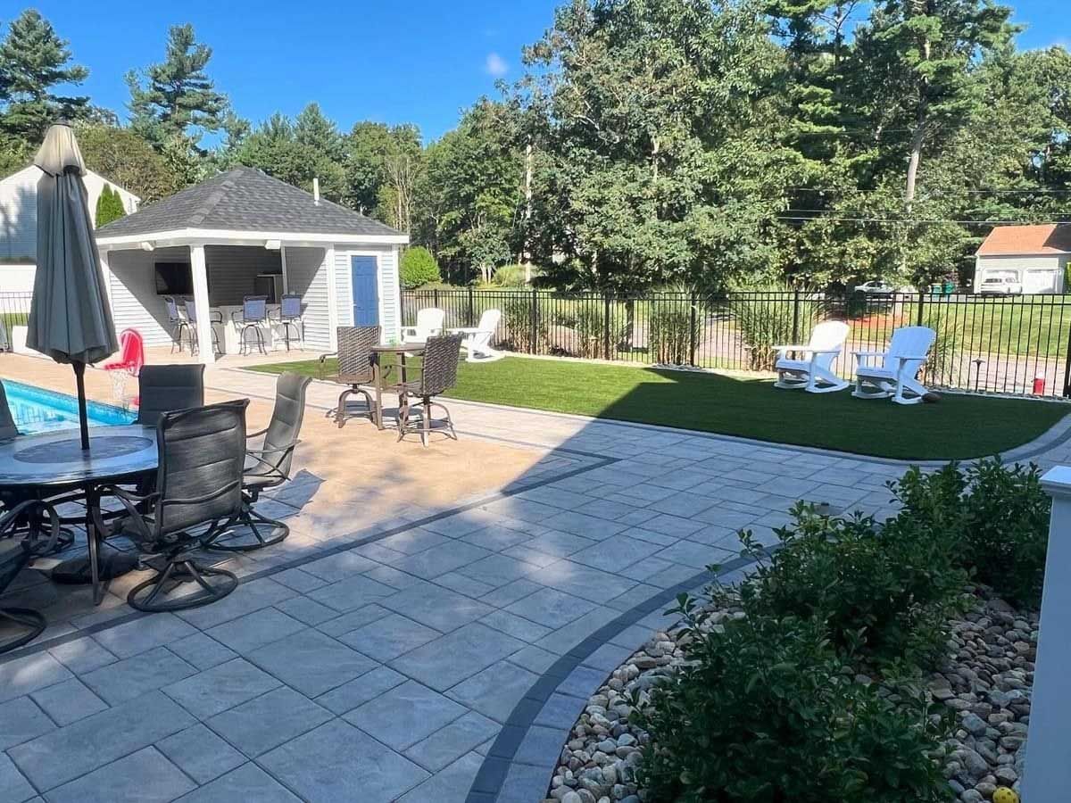 Backyard with a pool, patio, outdoor seating, and a gazebo on a sunny day.