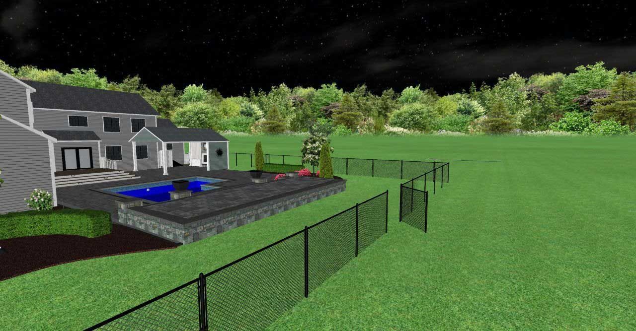 Night view of a house with a pool, surrounded by a fence and grass, with trees in the background.