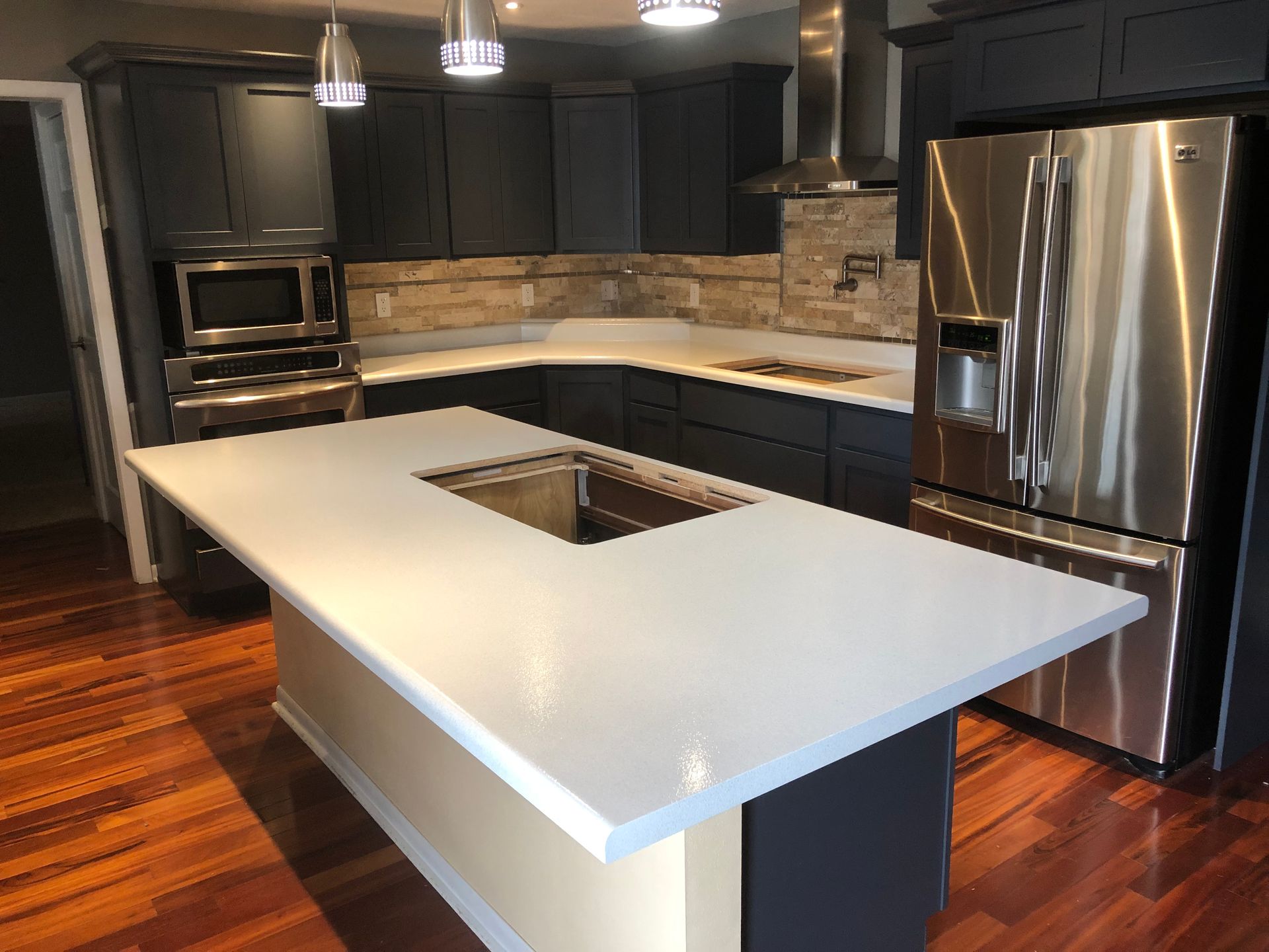 A kitchen with granite countertops and black cabinets is being remodeled - after