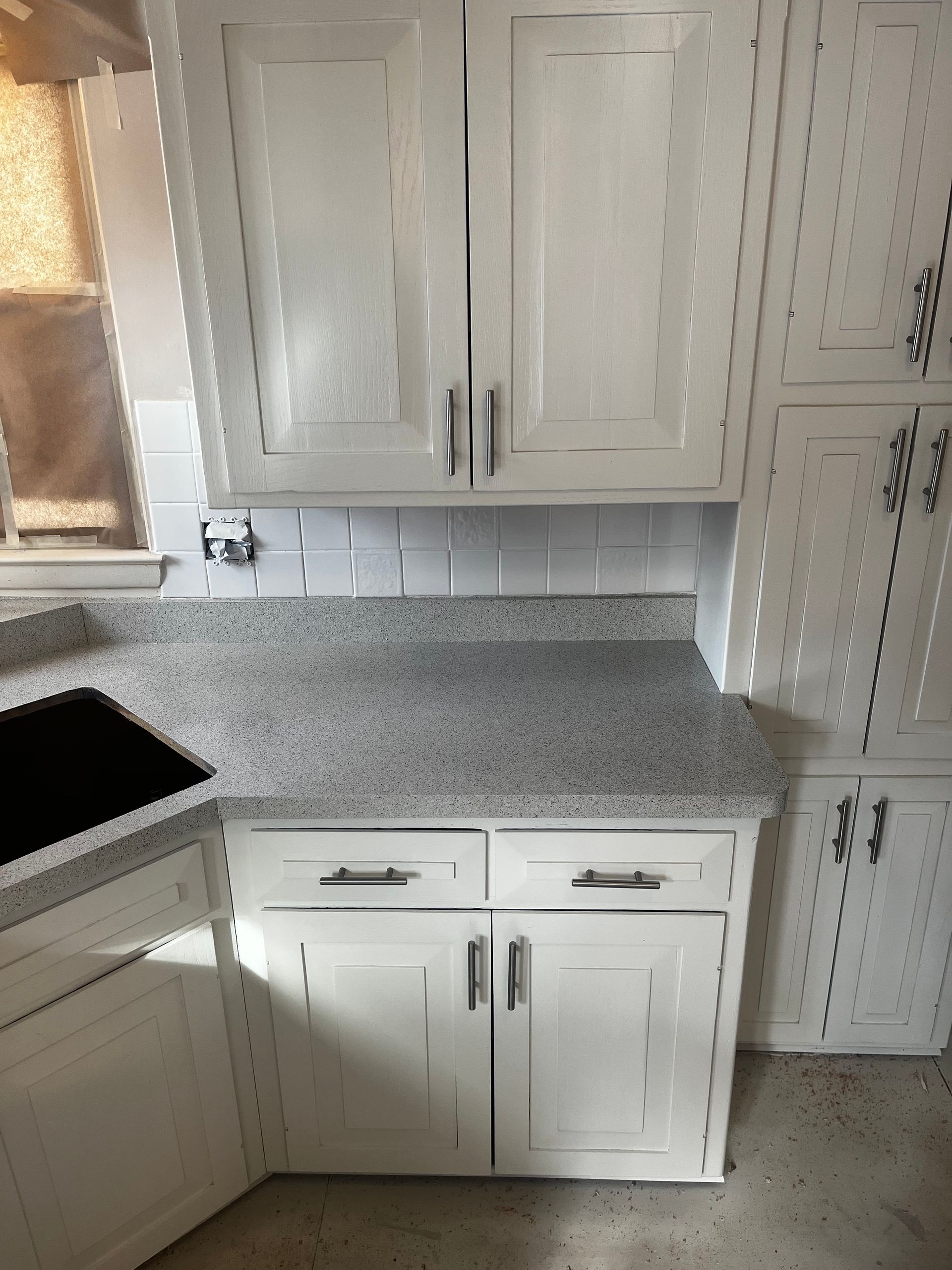 A kitchen with wooden cabinets, a sink, and a window - after