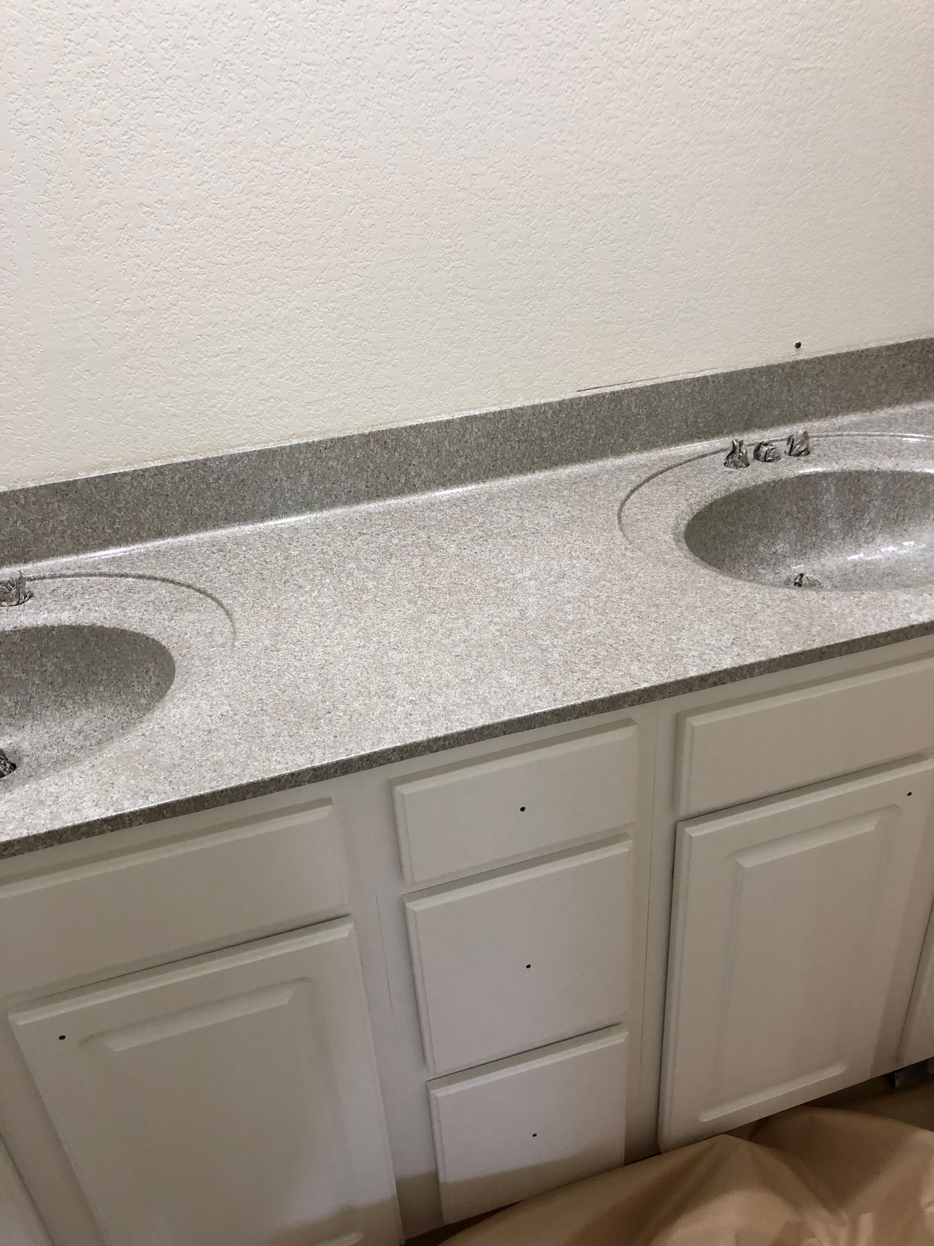 A bathroom with two sinks and white cabinets - after