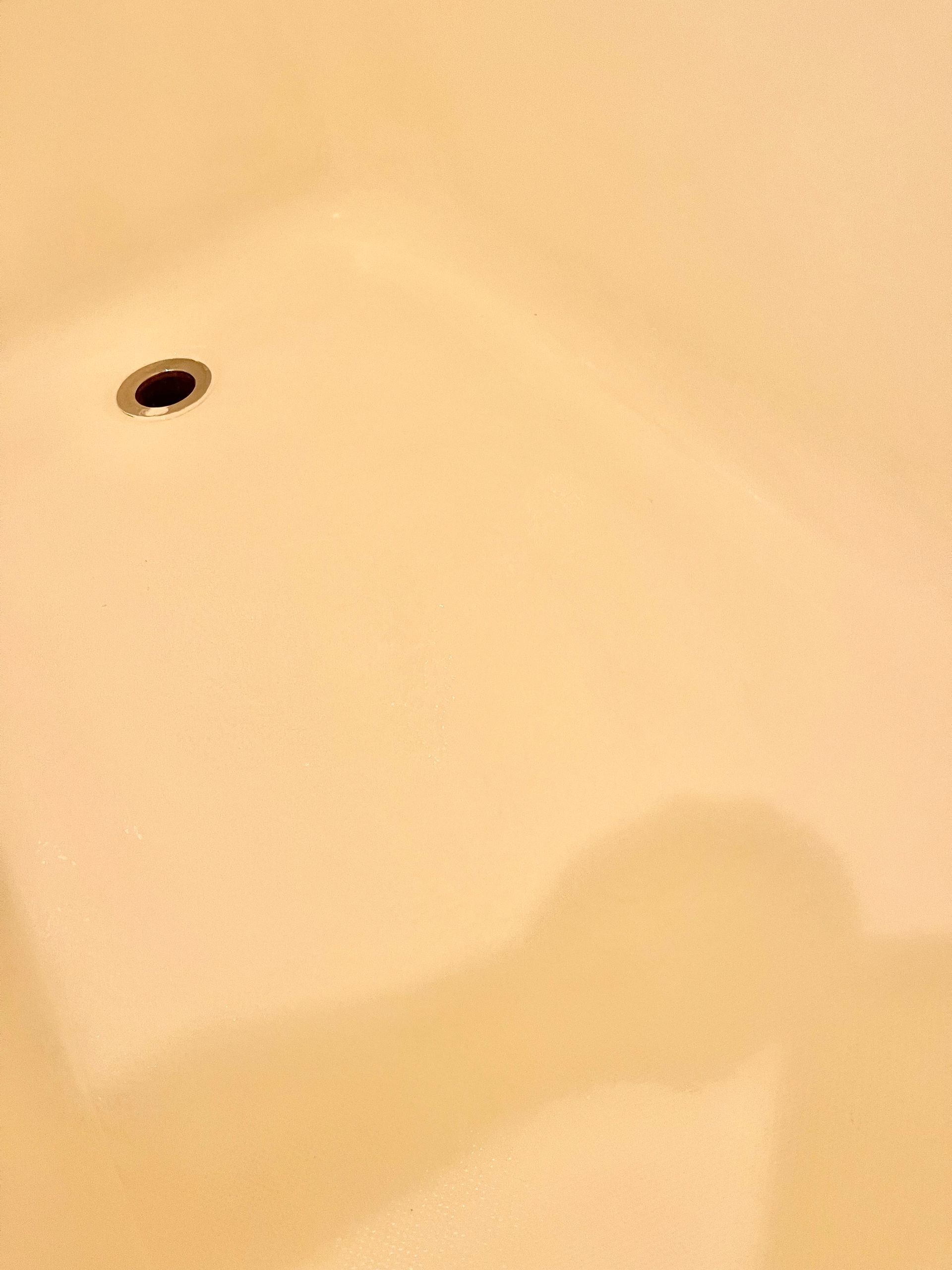 A close-up of a bathtub with a hole in it - after