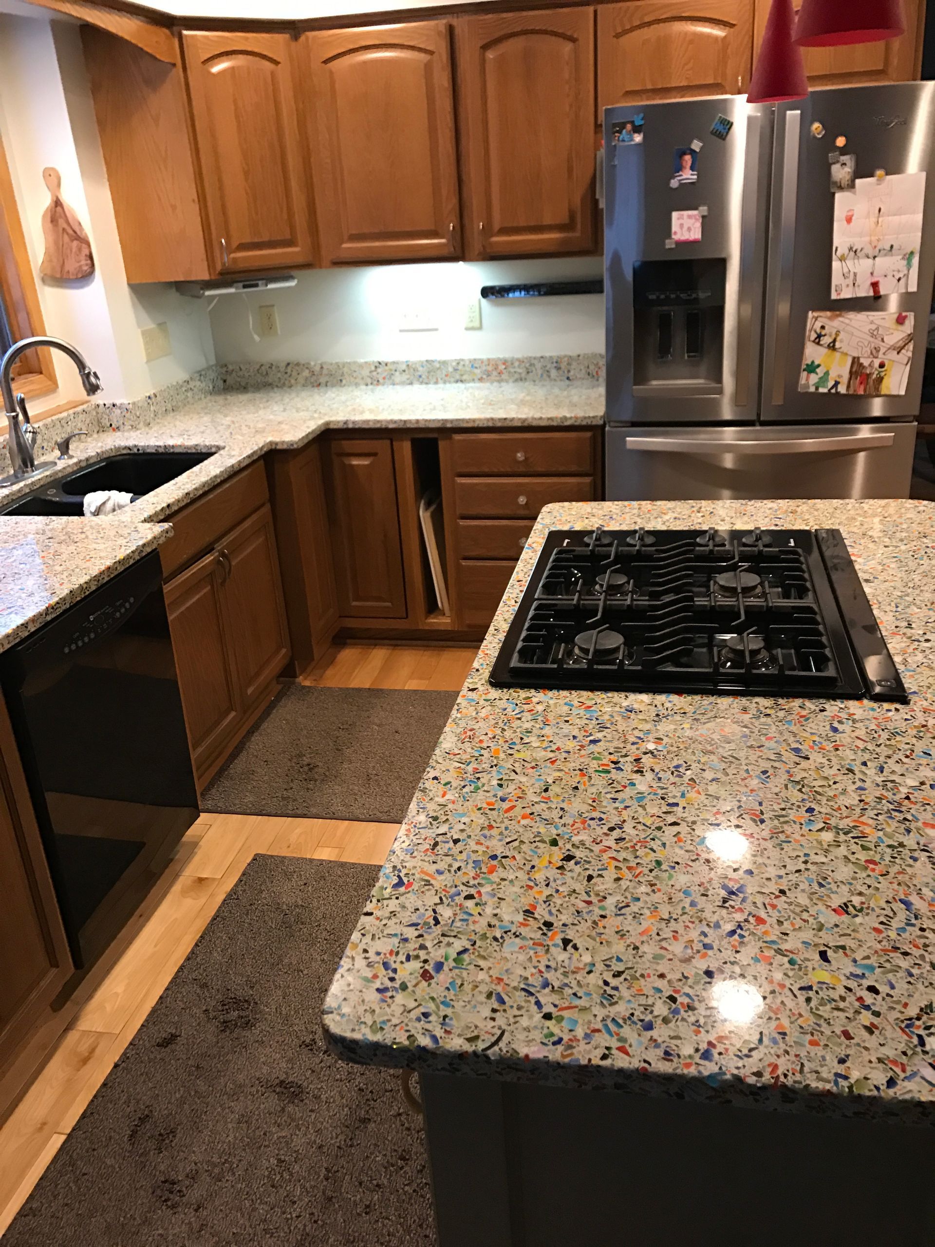 A kitchen with a stove top oven, refrigerator, sink, and dishwasher - before