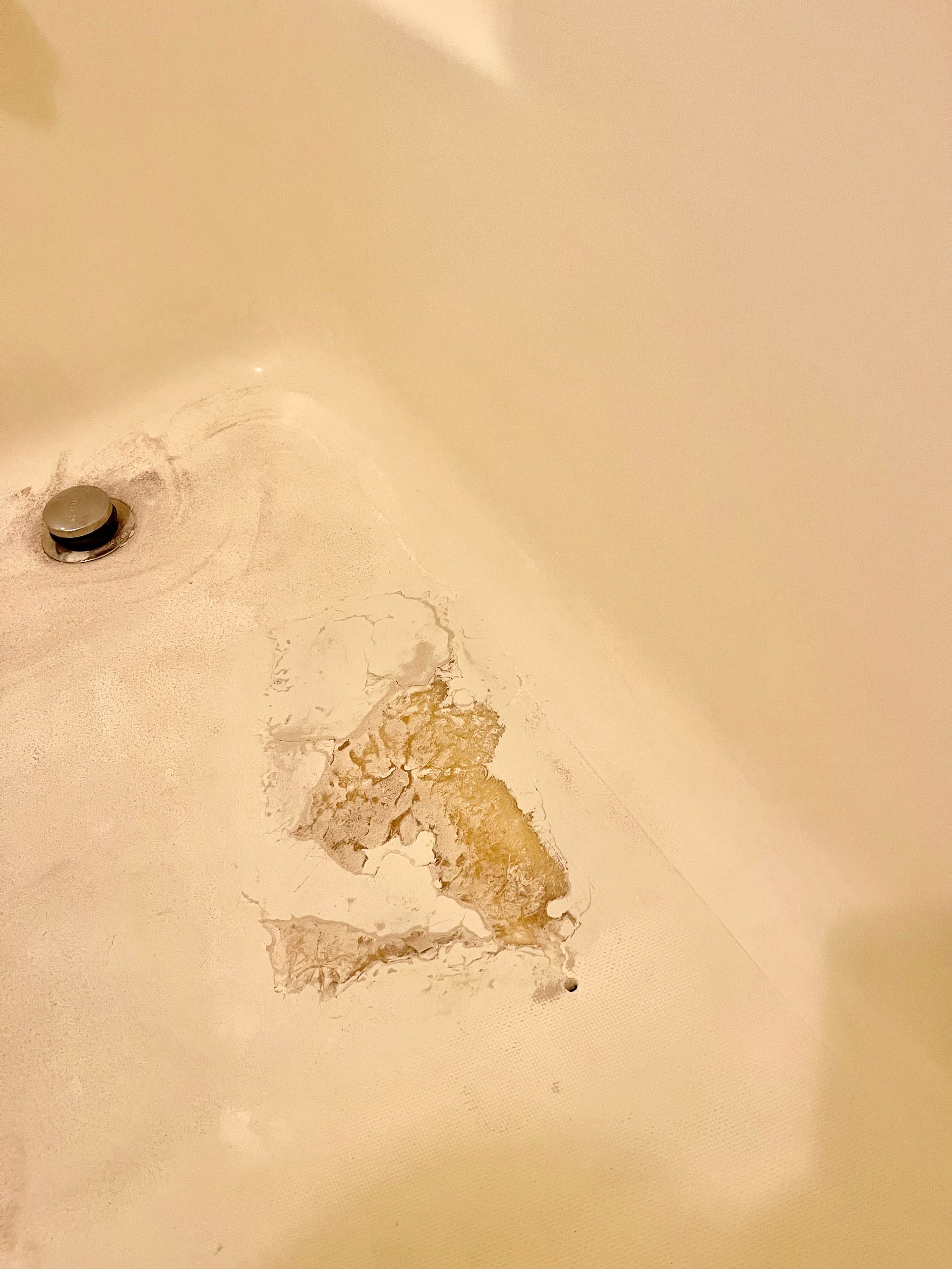 A close-up of a bathtub with a hole in it - before