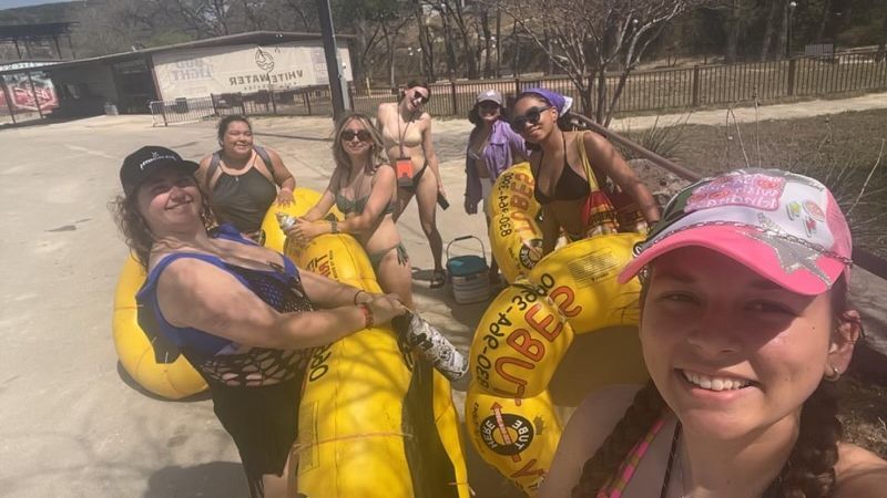 A group of women are standing next to each other on rafts.