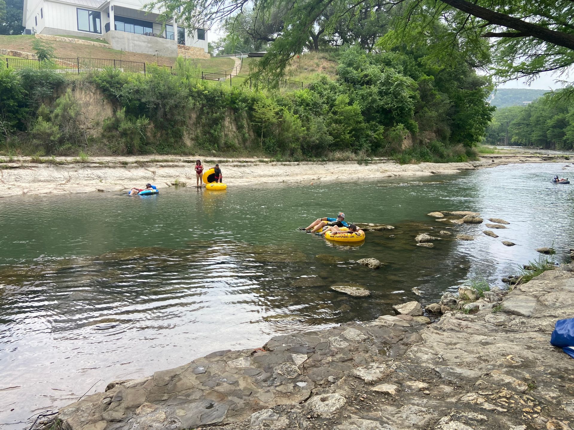 A group of people are floating down a river in tubes.