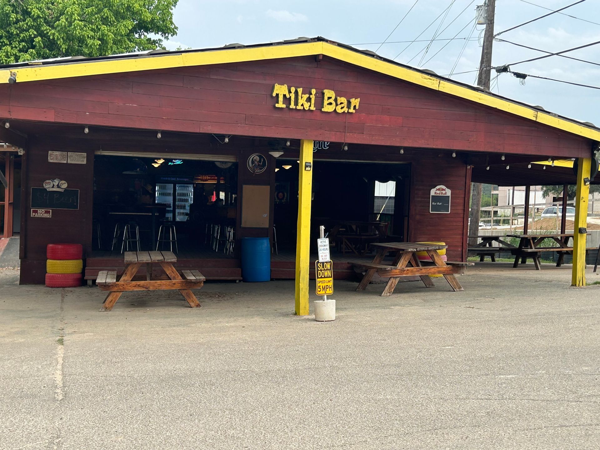 A tiki bar with picnic tables in front of it