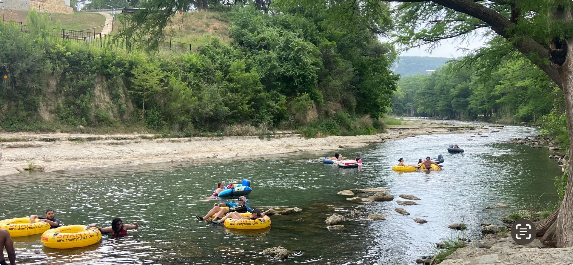 A group of people are floating down a river on tubes.