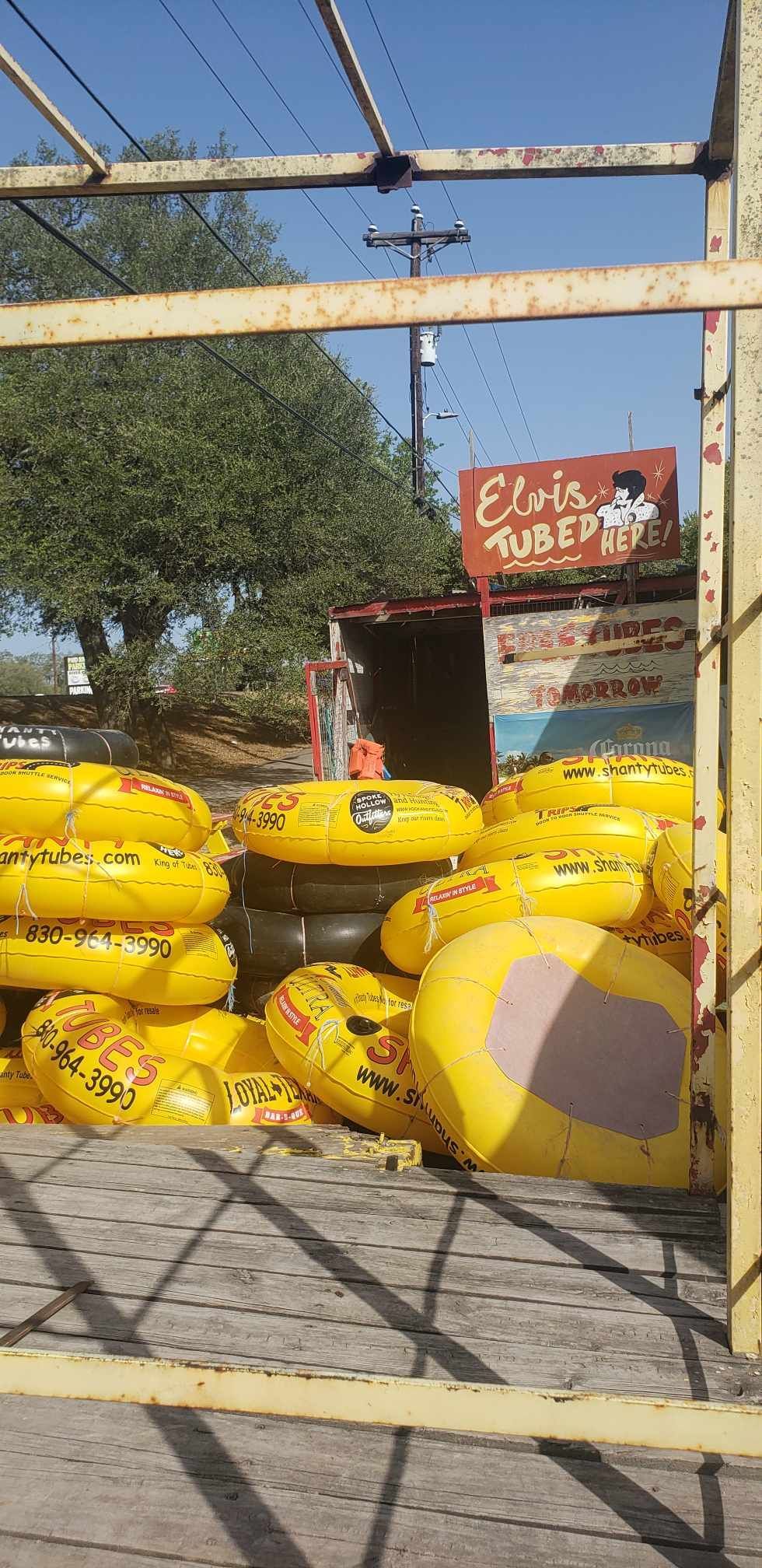 A bunch of yellow tubes are stacked on top of each other in front of a building.