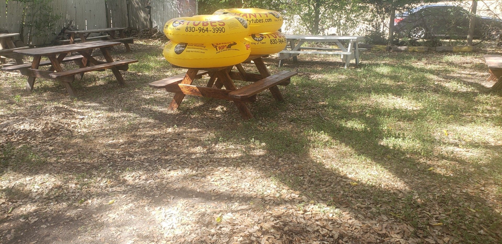 A bunch of yellow tubes are sitting on top of a picnic table.