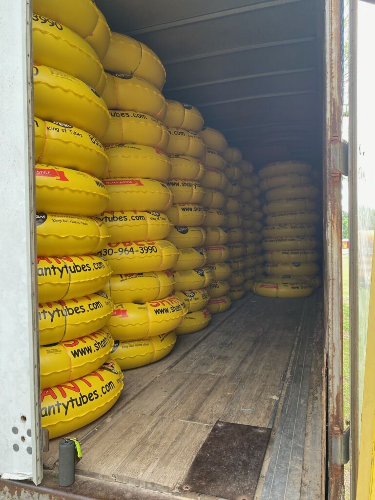 A bunch of yellow tubes are stacked on top of each other in a truck.