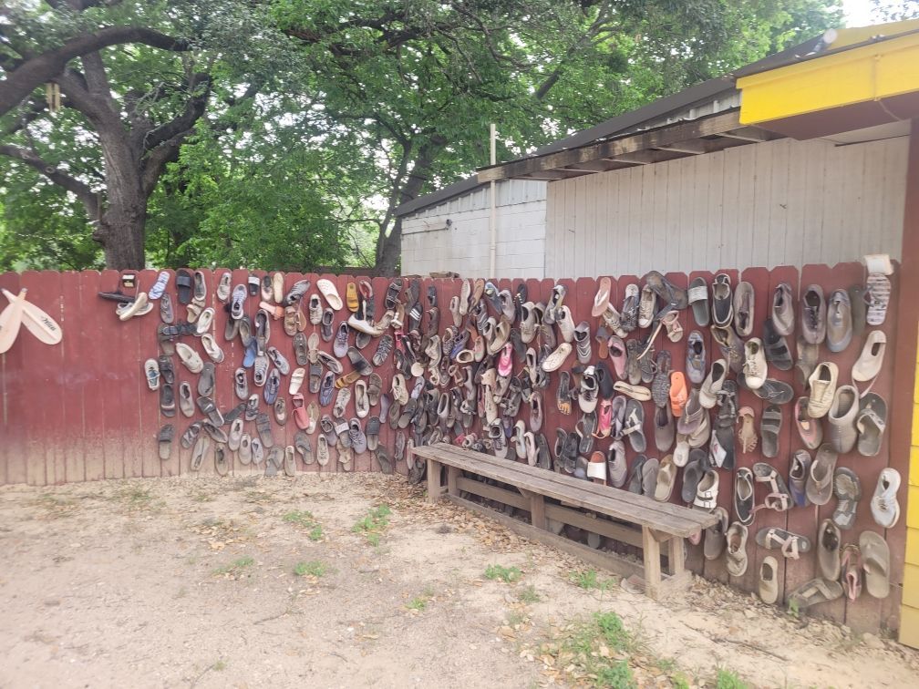 A fence with a lot of shoes on it