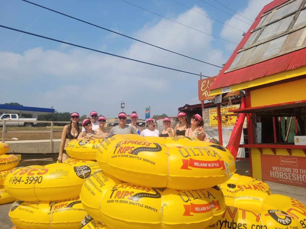 A group of people are standing in front of a stack of yellow tubes.