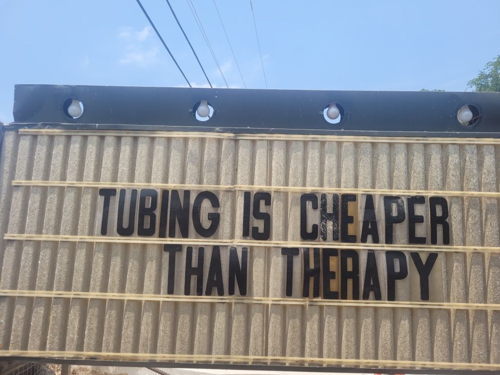 A sign that says tubing is cheaper than therapy