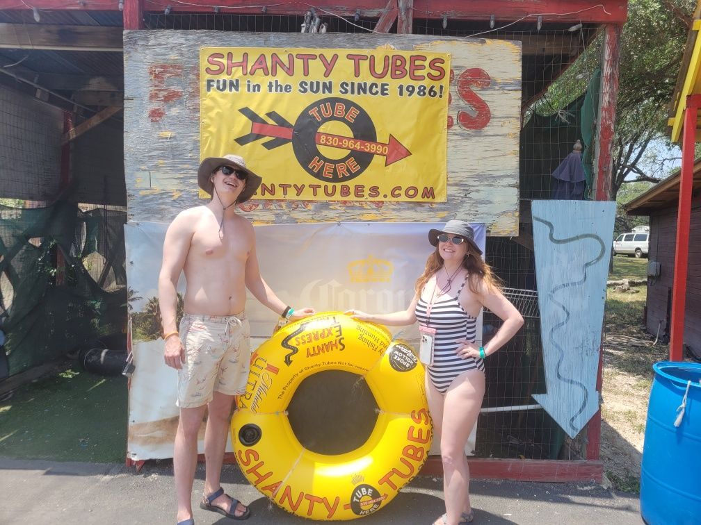 A man and a woman standing in front of a sign that says shanty tubes