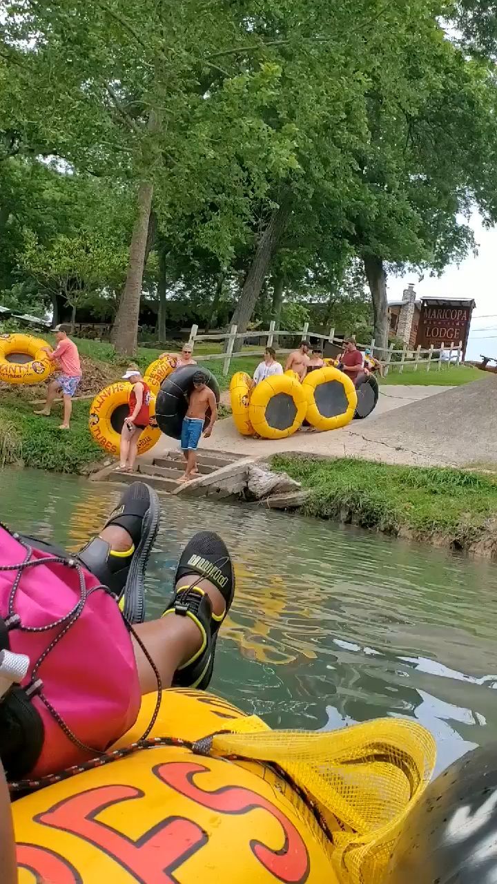 A group of people are riding inner tubes down a river.