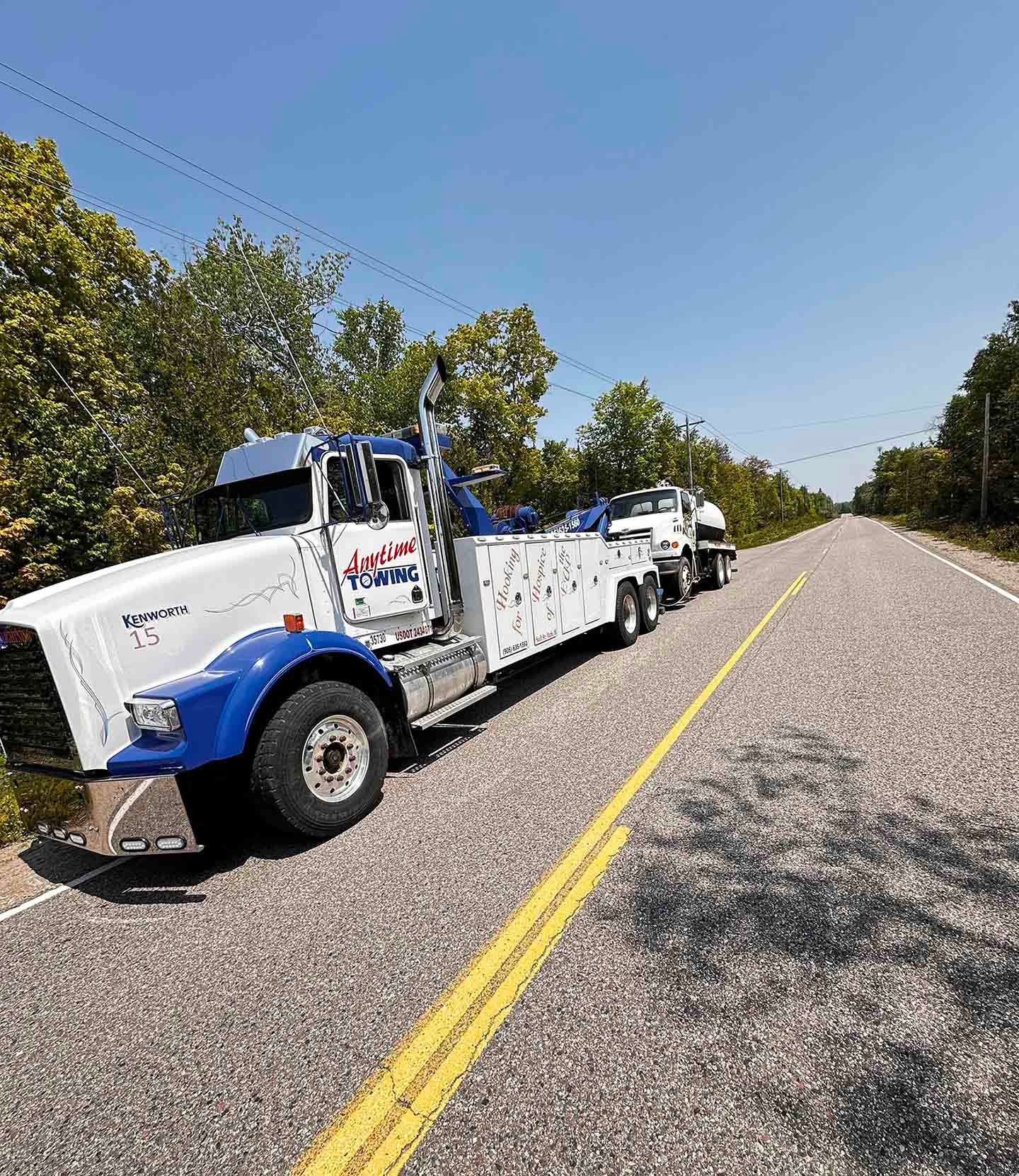 Tow truck on a road, towing a vehicle