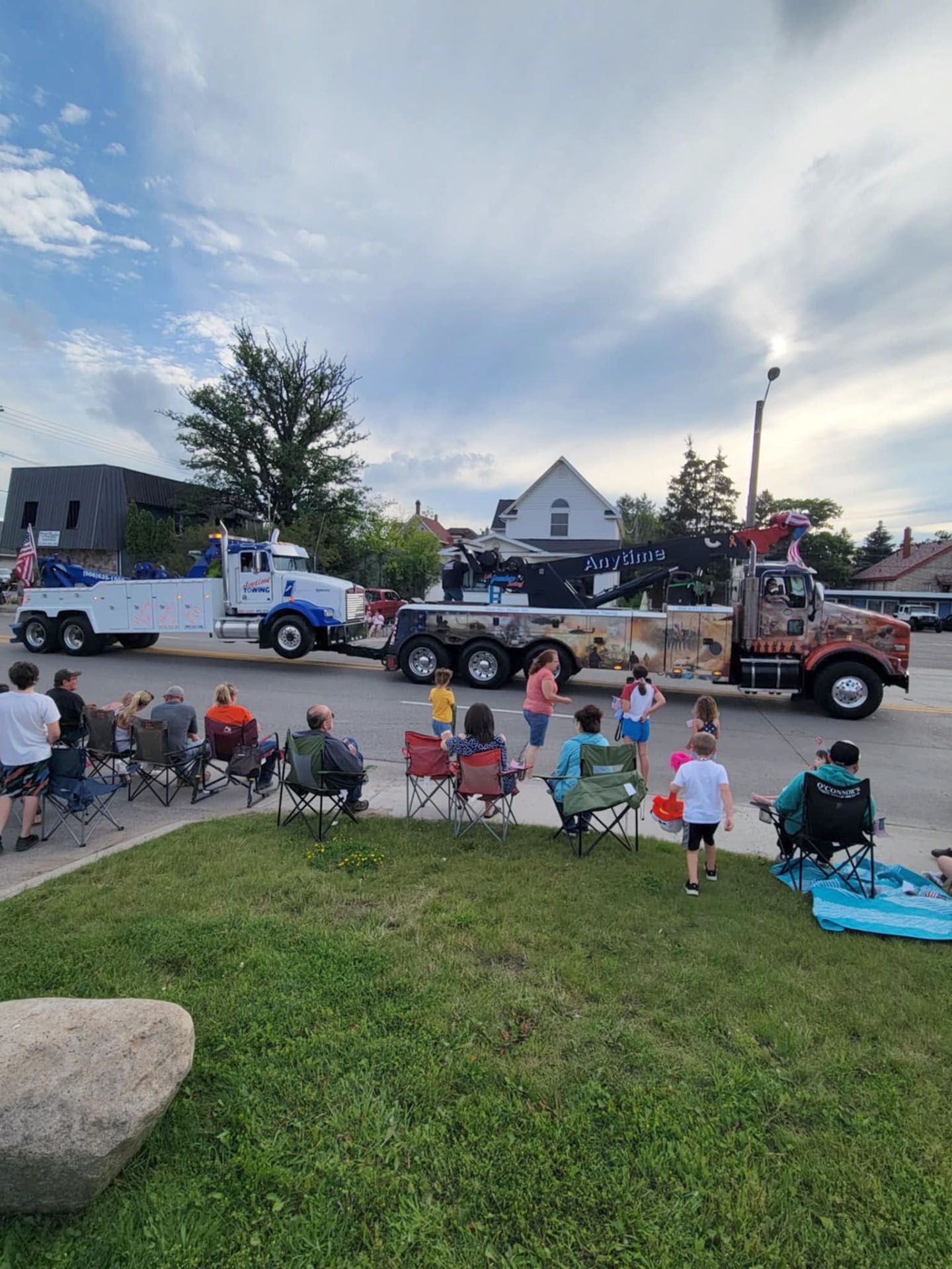 People watching tow trucks in a parade