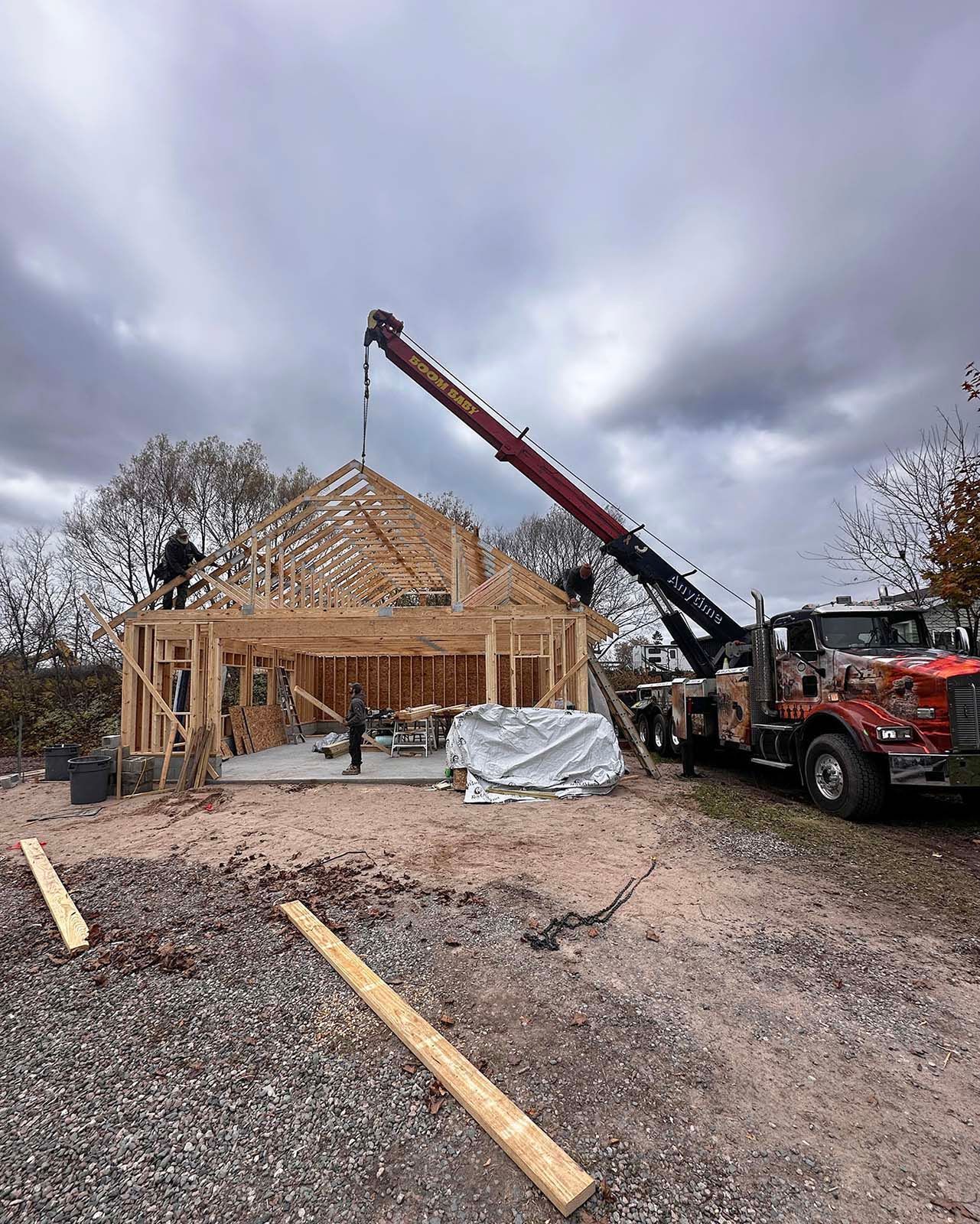 Construction site with a crane lifting roof trusses