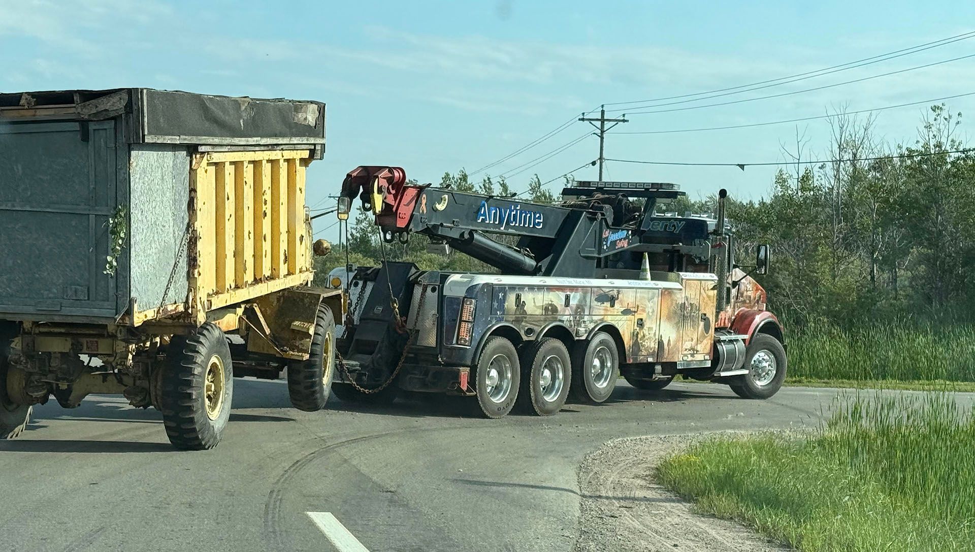 Tow truck hooking up to a yellow trailer