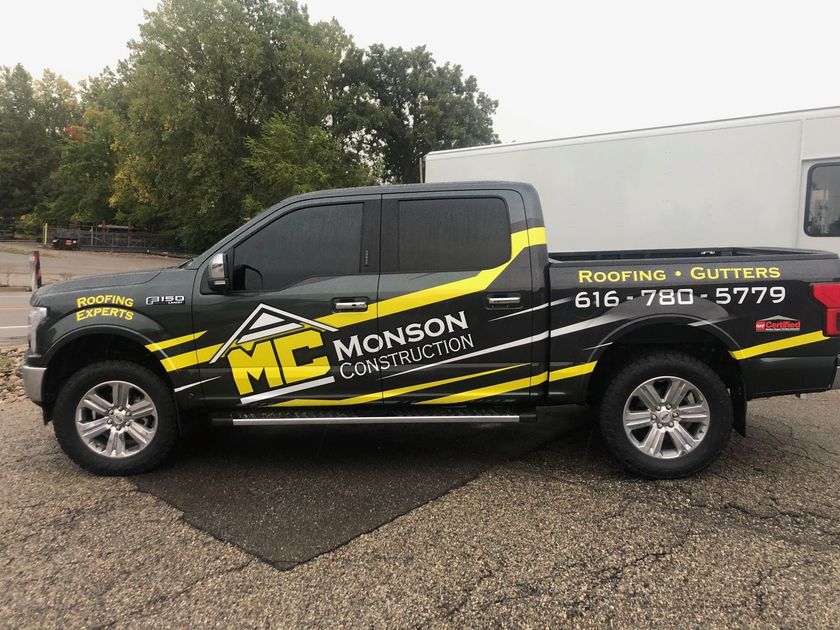 A black and yellow truck is parked on the side of the road.