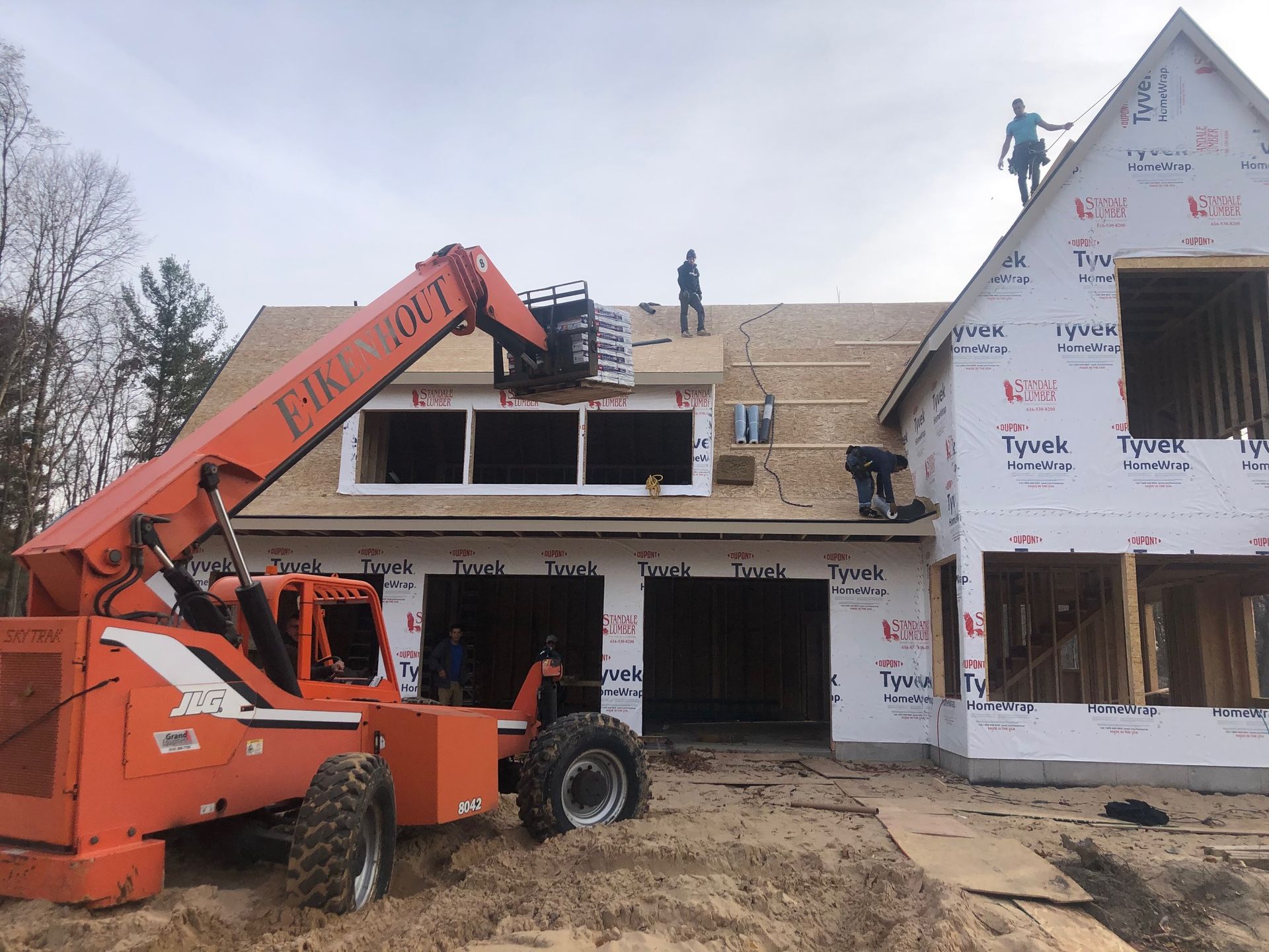 A house is being built with a forklift in front of it.