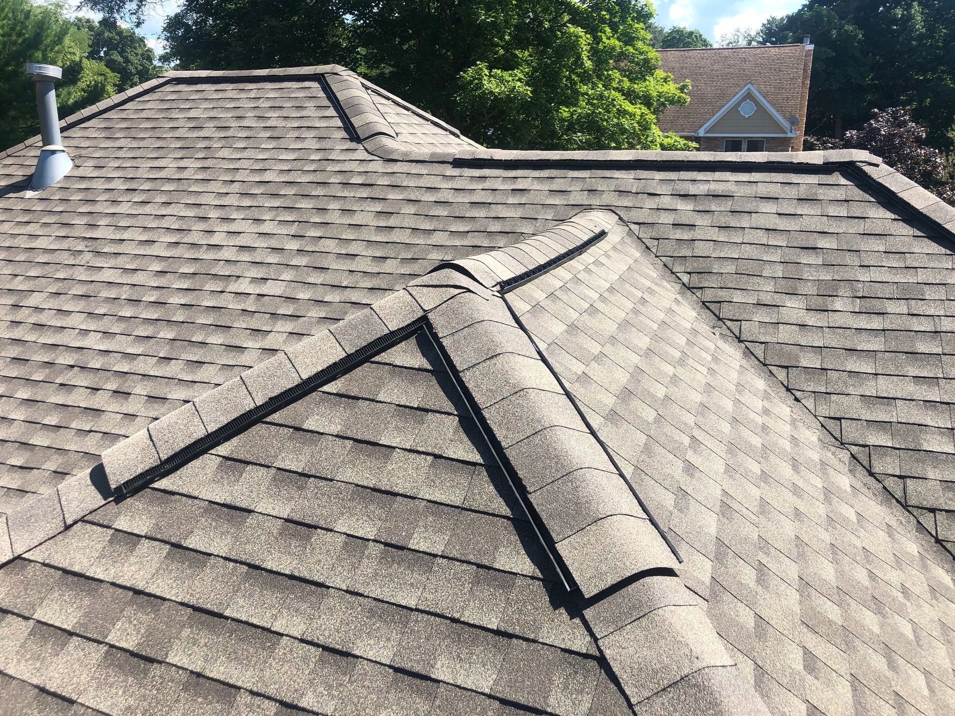 A close up of a roof with shingles and a chimney.