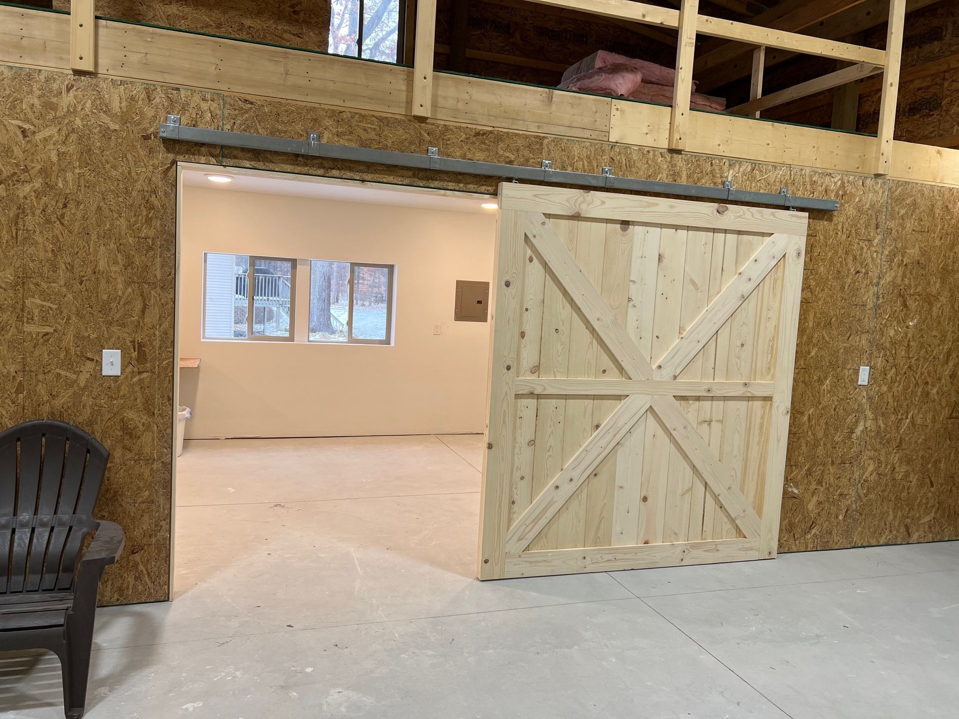 A wooden sliding barn door is open to a room.