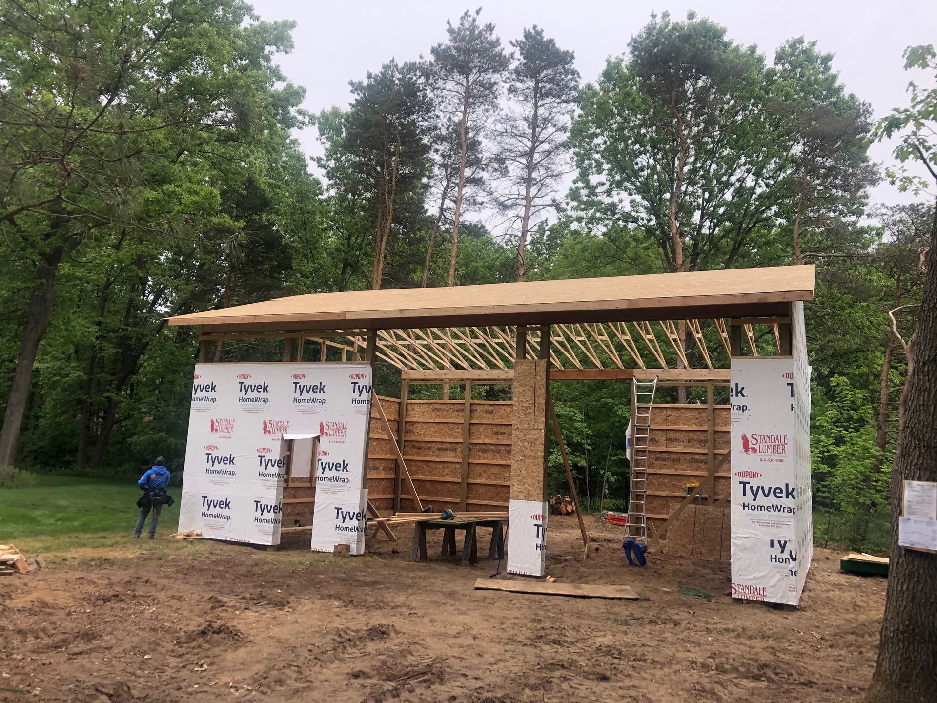 A wooden structure is being built in the middle of a forest.