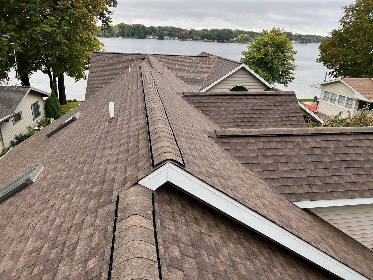 The roof of a house with a lake in the background