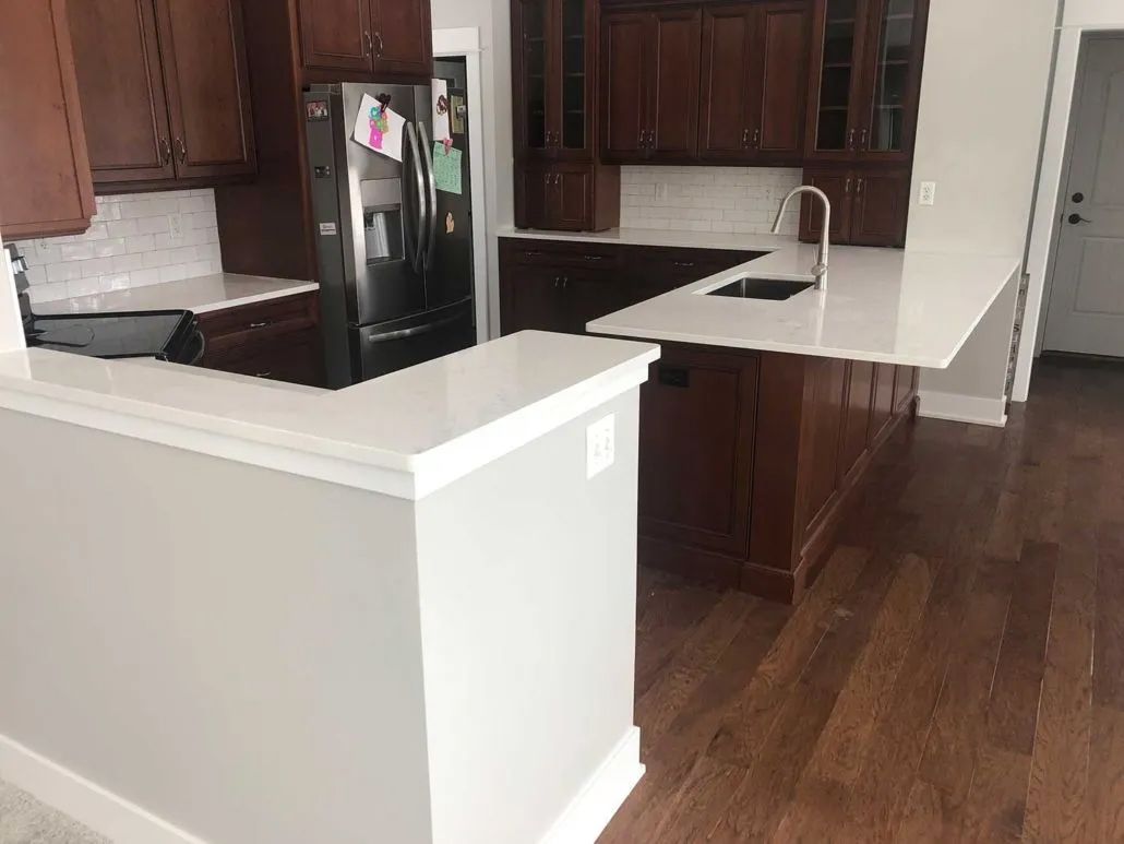 A kitchen with a refrigerator , sink , and wooden cabinets.