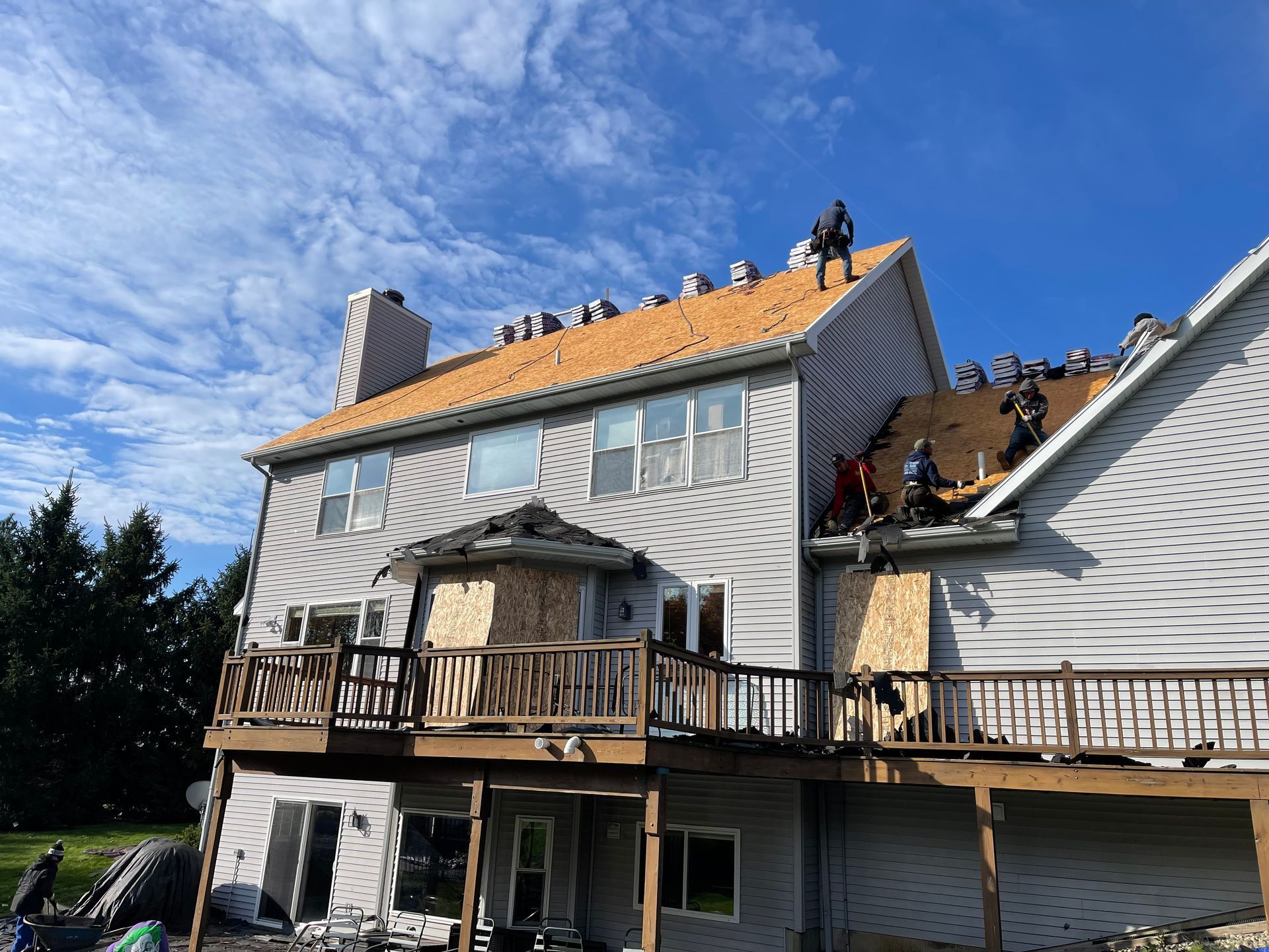 A group of people are working on the roof of a house.