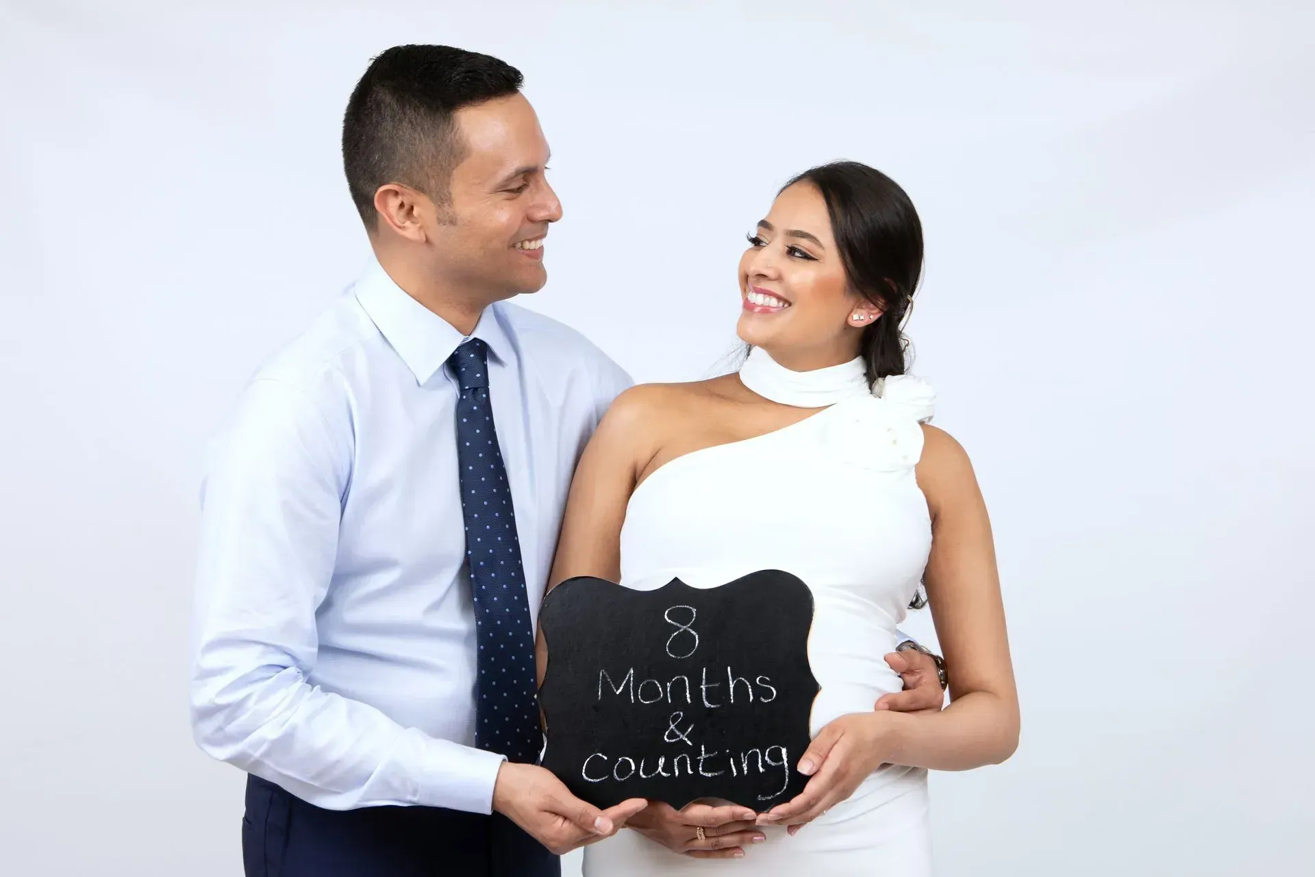 Couple holding a chalkboard sign that reads 